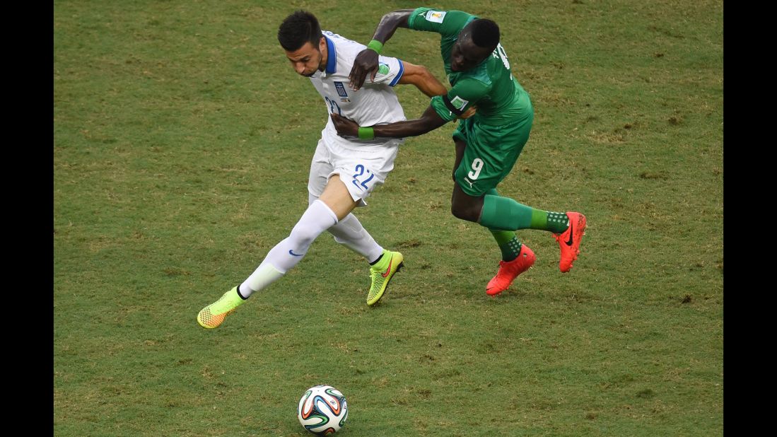Greece's Andreas Samaris, left, fights for the ball with Ivory Coast's Ismael Cheick Tiote.