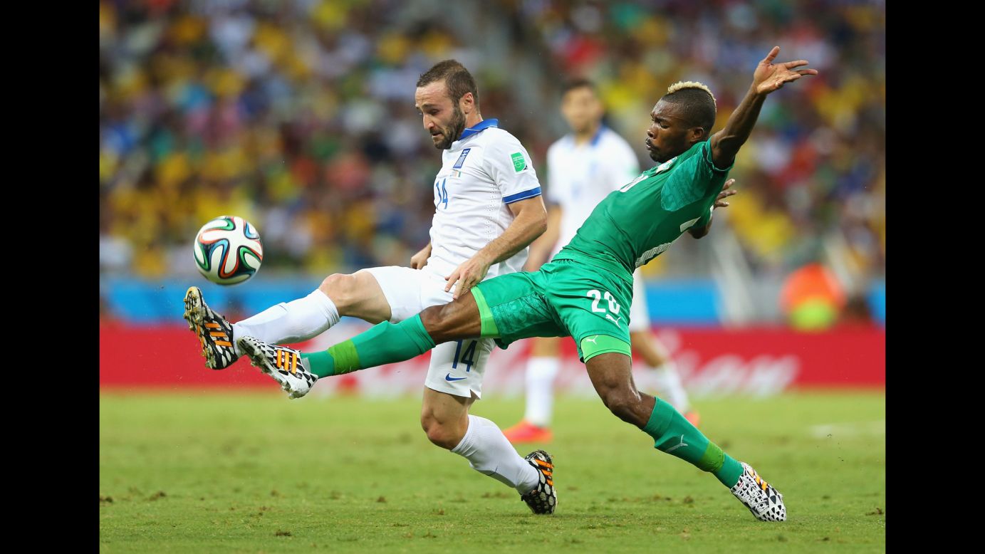 Dimitris Salpingidis of Greece, left, and Die Serey of the Ivory Coast compete for the ball.