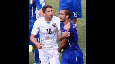Television pictures showed Suarez dipping his head towards Chiellini, right, and when the Italian defender eventually got up, he pulled down his shirt and appeared to furiously indicate that he had been bitten on the shoulder.