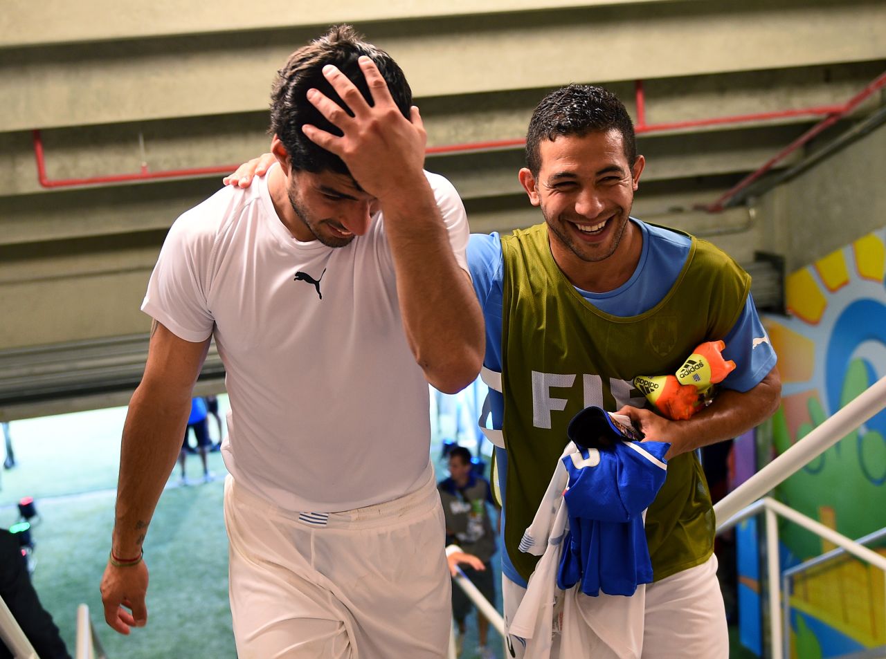 Suarez, left, celebrates the 1-0 win against Italy with his teammate Walter Gargano in the tunnel after the controversial match at Estadio das Dunas.