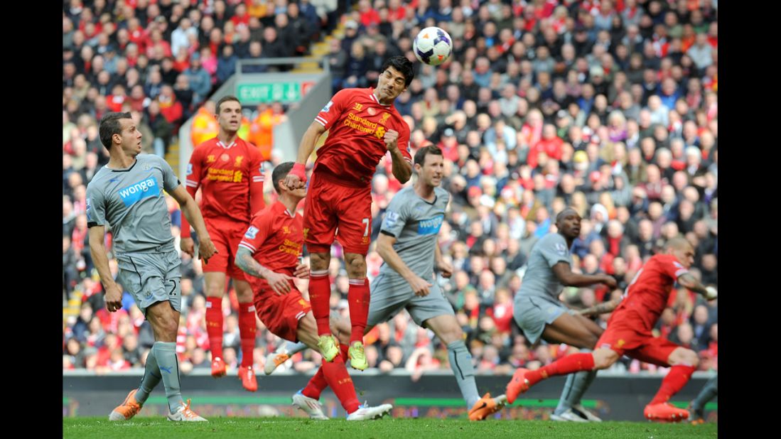 Suarez, fourth from left, heads the ball for teammate Daniel Sturridge to score his team's second goal during the English Premier League football match between Liverpool and Newcastle United on May 11.