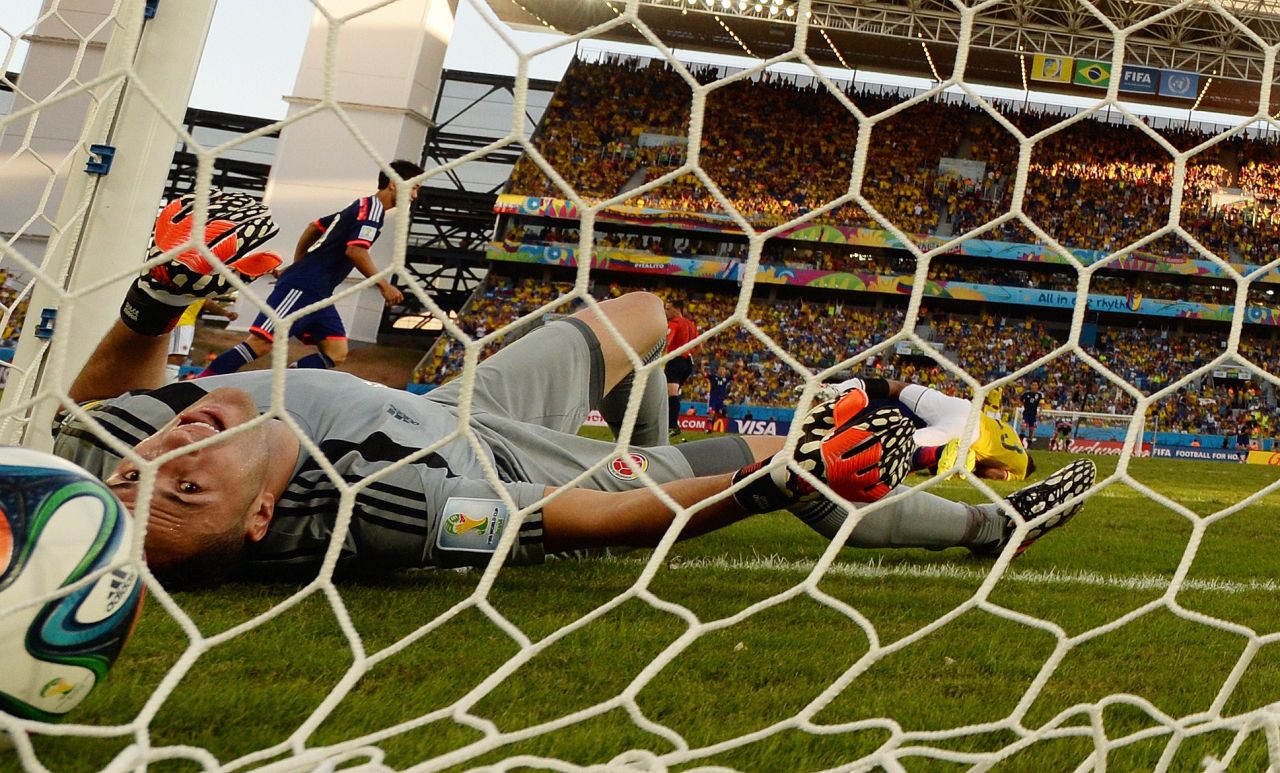 Colombia's goalkeeper David Ospina lies on the ground after Japan's Shinji Okazaki (not pictured) scored his team's first goal.