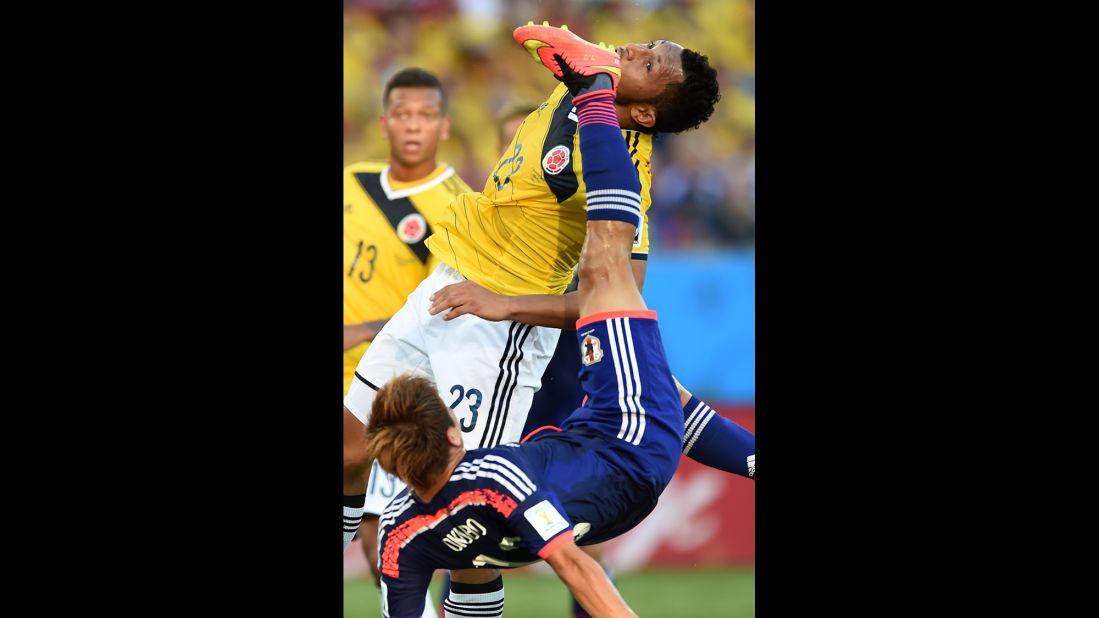 Japan's Yoshito Okubo, bottom, and Colombia's Carlos Valdes vie for the ball.