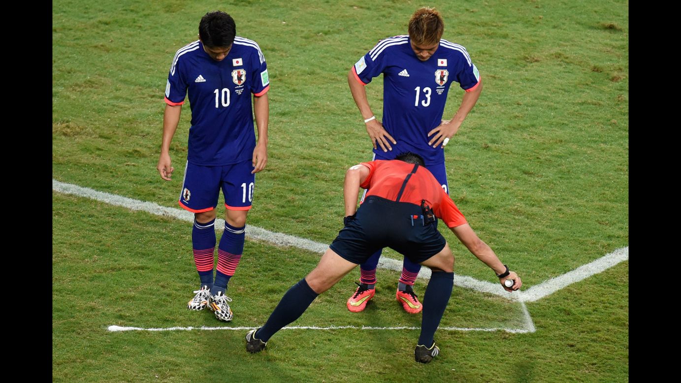 Referee Pedro Proenca sprays a free kick line during the match between Japan and Colombia.