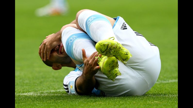 Javier Mascherano of Argentina falls to the ground wincing.