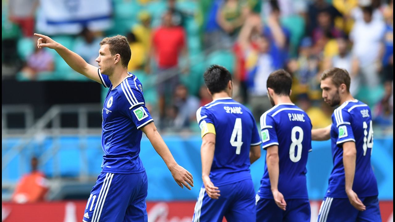 Bosnia-Herzegovina forward Edin Dzeko, left, celebrates scoring his team's first goal against Iran.