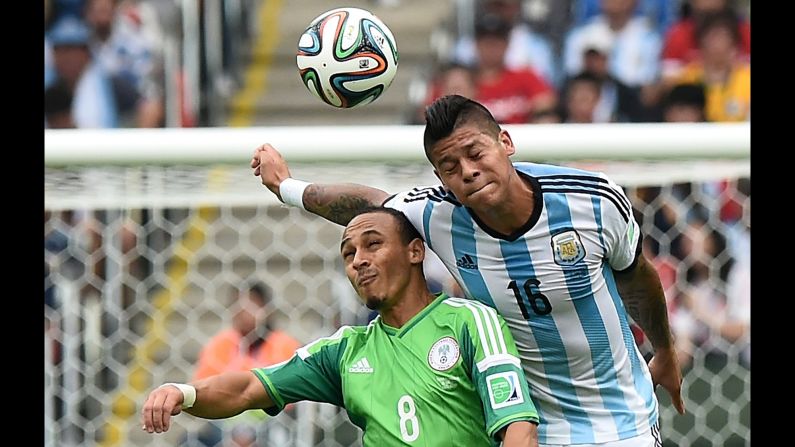 Argentina defender Marcos Rojo, right, challenges Nigeria forward Peter Odemwingie for the ball.  