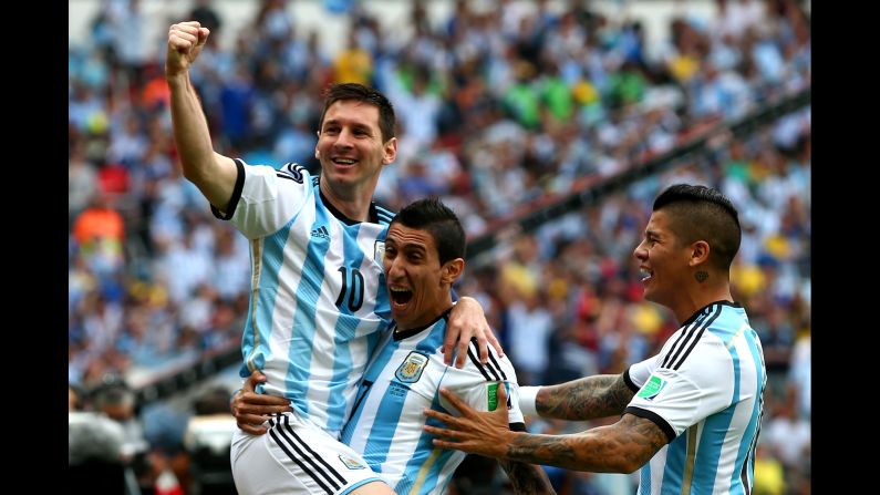 Lionel Messi, left, of Argentina celebrates scoring his team's first goal with his teammates Angel di Maria, center, and Marcos Rojo, right, during the match between Nigeria and Argentina. 