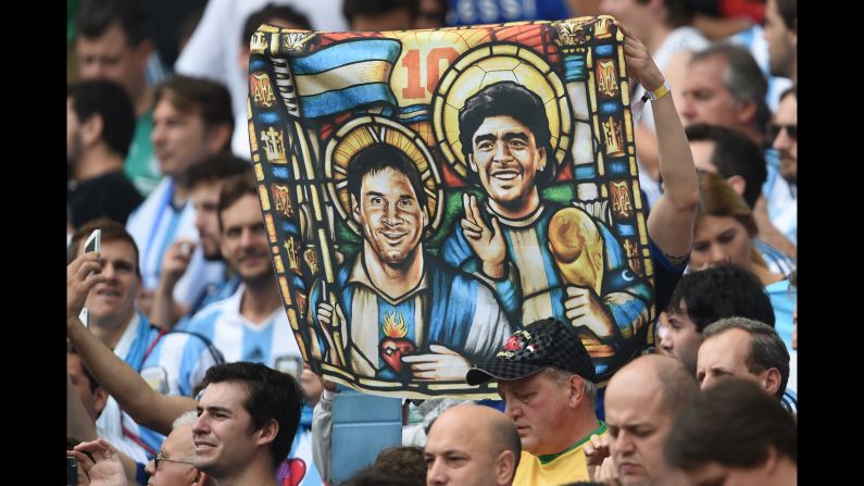 A fan holds an image of Argentina forward Lionel Messi and the legendary Diego Maradona depicted as religious icons. <a href="index.php?page=&url=http%3A%2F%2Fwww.cnn.com%2F2014%2F06%2F24%2Ffootball%2Fgallery%2Fworld-cup-0624%2Findex.html">See the best World Cup photos from June 24.</a>