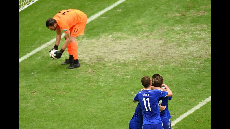 Bosnia-Herzegovina forward Edin Dzeko, front right, celebrates with teammates after Bosnia-Herzegovina midfielder Miralem Pjanic (not seen) scored his team's second goal. Haghighi, picks up the ball 