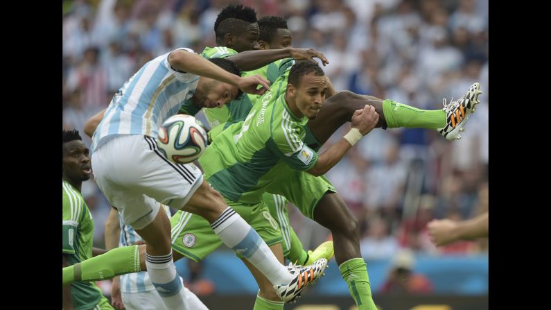 Argentina's defender Ezequiel Garay, left, and Nigeria's forward Peter Odemwingie, center, jump to head the ball, during a match between Nigeria and Argentina at the Beira-Rio Stadium in Porto Alegre.