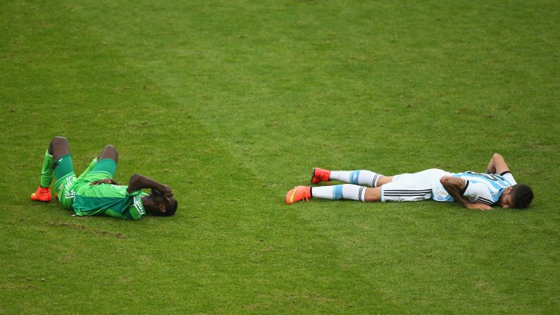 Juwon Oshaniwa of Nigeria and Ricardo Alvarez of Argentina lie on the field after a collision. 