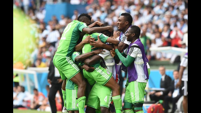 Nigeria's forward Ahmed Musa is mobbed by teammates as he celebrates scoring. 