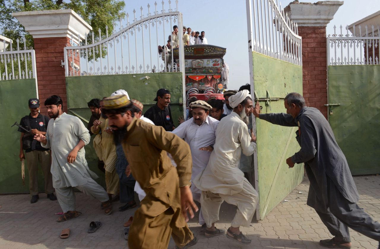 Displaced Pakistanis force their way into a food distribution center.