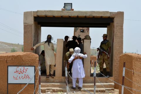 A Pakistani soldier frisks a civilian at the Bannu Frontier Region registration point for displaced people on June 22. At registration centers, people are receiving cash handouts to buy food and other items, the U.N. says.