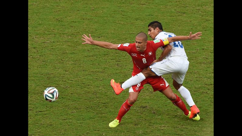 Honduras midfielder Jorge Claros, right, challenges Switzerland midfielder Goekhan Inler.