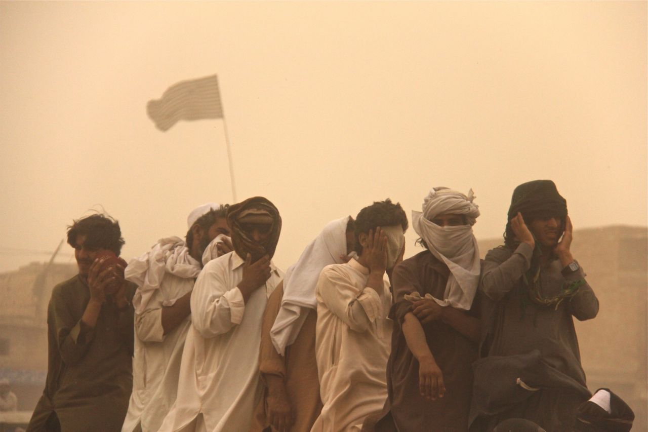 Hundreds of men, young and old, queued up outside on the streets to receive rations, shielding their eyes from the grit.
