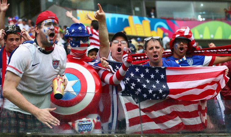A pesar de la torrencial lluvia, fanáticos estadounidenses disfrutan de la atmósfera antes del encuentro Alemania-Estados Unidos en el Arena Pernambuco en Recife. 