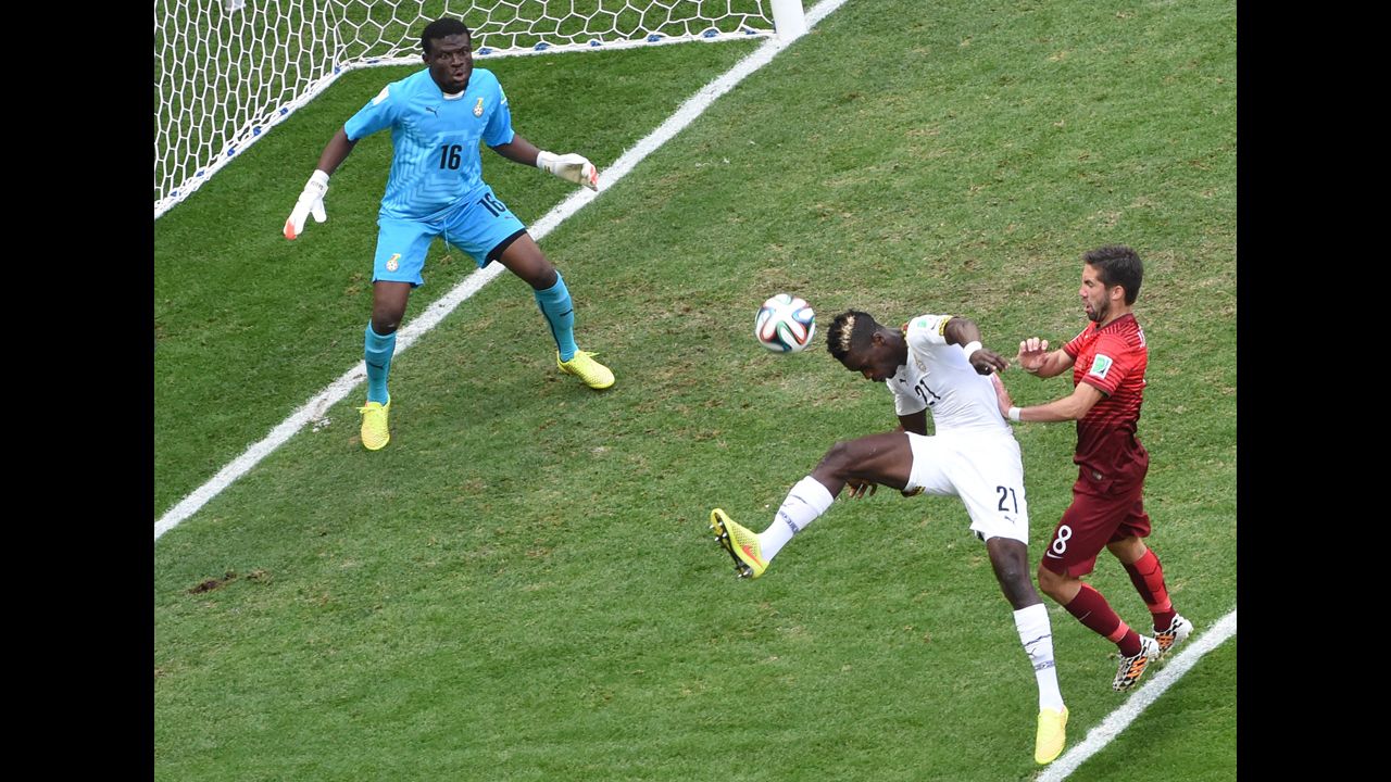 Ghana defender John Boye, center, hits the ball to score an own-goal as Portugal midfielder Joao Moutinho, right, watches on and Ghana goalkeeper Fatau Dauda tries to defend on June 26.