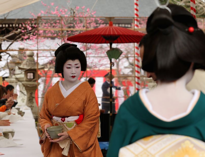 A full-fledged geisha serves tea during Kyoto's annual Plum Blossom Festival. Aside from their regular hosting engagements, trained geisha are often hired to perform at local festivals. 