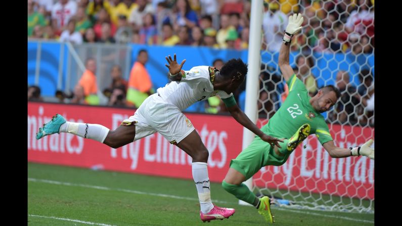 Ghana forward and captain Asamoah Gyan, left, scores past Portugal's goalkeeper Beto during the match between Portugal and Ghana.
