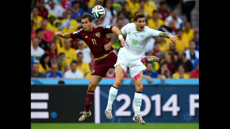 Aleksandr Kerzhakov of Russia and Carl Medjani of Algeria compete for the ball.