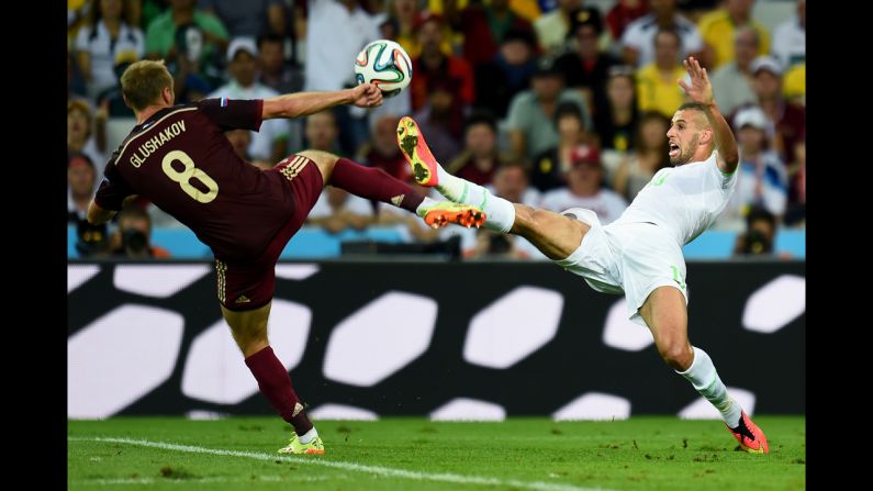 Islam Slimani of Algeria and Denis Glushakov of Russia compete for the ball.