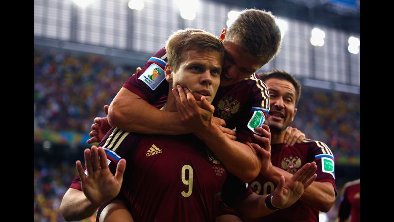 Kokorin celebrates scoring his team's first goal with teammate Oleg Shatov on his back in a match against Algeria. 