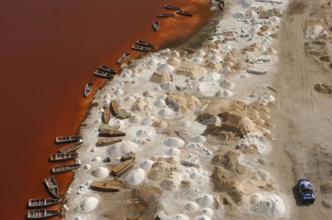 Piles of salt drying on the shores of Lake Retba. The lake's salt content rivals that of the Dead Sea and the combination of the sun and salt-loving micro-algae has given the water its color. 