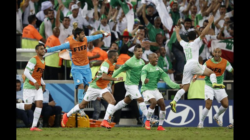 Algerian squad members celebrate after tying Russia 1-1 during a World Cup match at the Baixada Arena in Curitiba, Brazil, on June 26. 