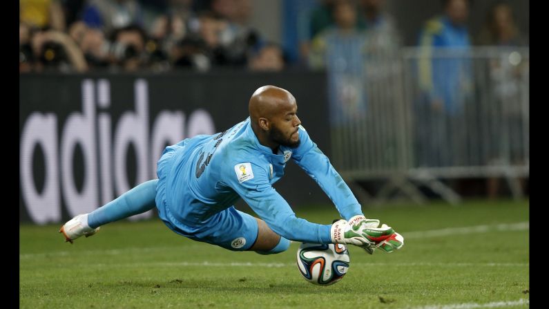 Algeria's goalkeeper Rais M'bohli dives for the ball.