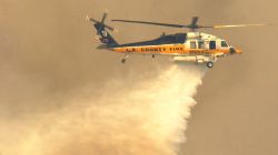 PALMDALE, CA - SEPTEMBER 4:  A Los Angeles County Fire Department Sikorsky UH60L Firehawk firefighting helicopter makes a waterdrop September 4, 2002 in Leona Valley, west of Palmdale, California. The Leona Valley Fire has burned more than 4,500 acres and several structures, including six homes.     (Photo by David McNew/Getty Images)