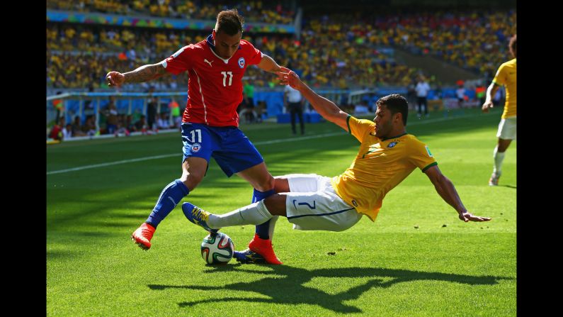 Hulk of Brazil tackles Eduardo Vargas of Chile.