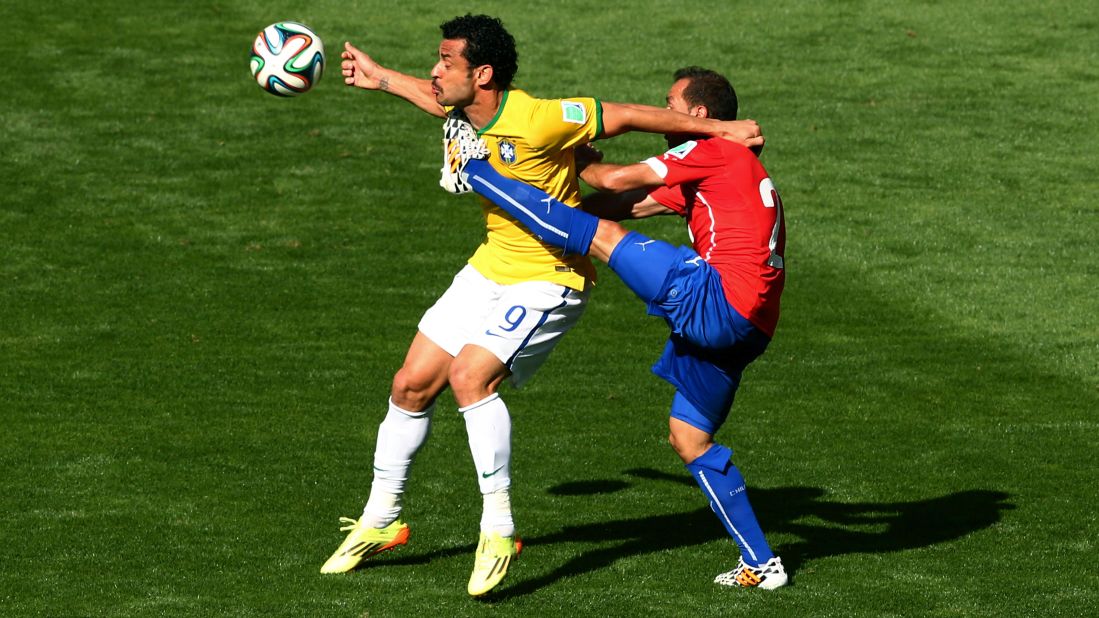 Fred of Brazil is challenged by Marcelo Diaz of Chile.