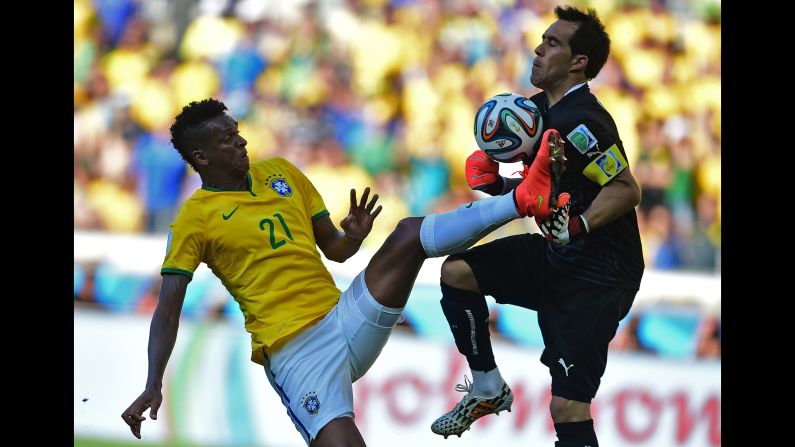 Jo of Brazil tries to score a goal as Chile's goalkeeper Claudio Bravo saves the ball.