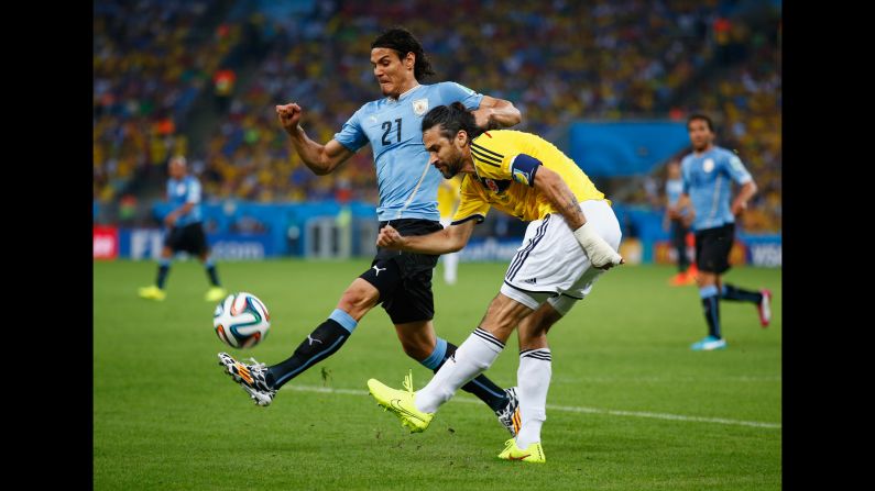 Edinson Cavani of Uruguay, left, challenges Mario Yepes of Colombia.