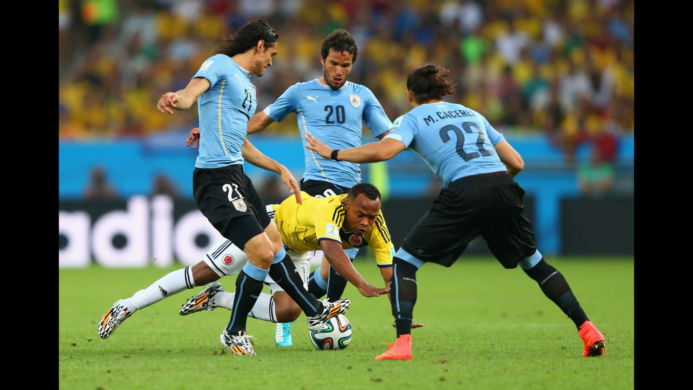 Juan Camilo Zuniga of Colombia is challenged by a trio of players from Uruguay.
