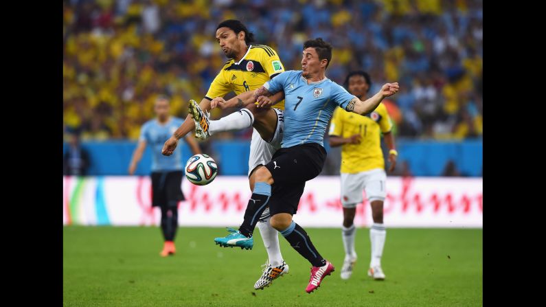 Abel Aguilar of Colombia and Cristian Rodriguez of Uruguay compete for the ball.
