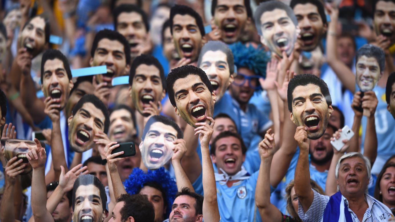 Uruguay fans hold up Luis Suarez masks before the game between Uruguay and Colombia. Suarez was banned from nine matches and four months of soccer-related activity after he bit an opponent in Uruguay's previous game.