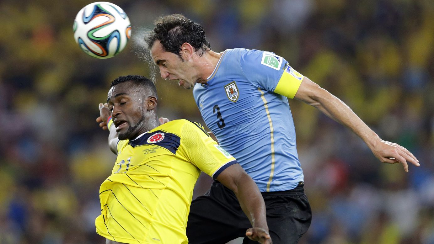 Colombia's Jackson Martinez and Uruguay's Diego Godin jump for the ball.