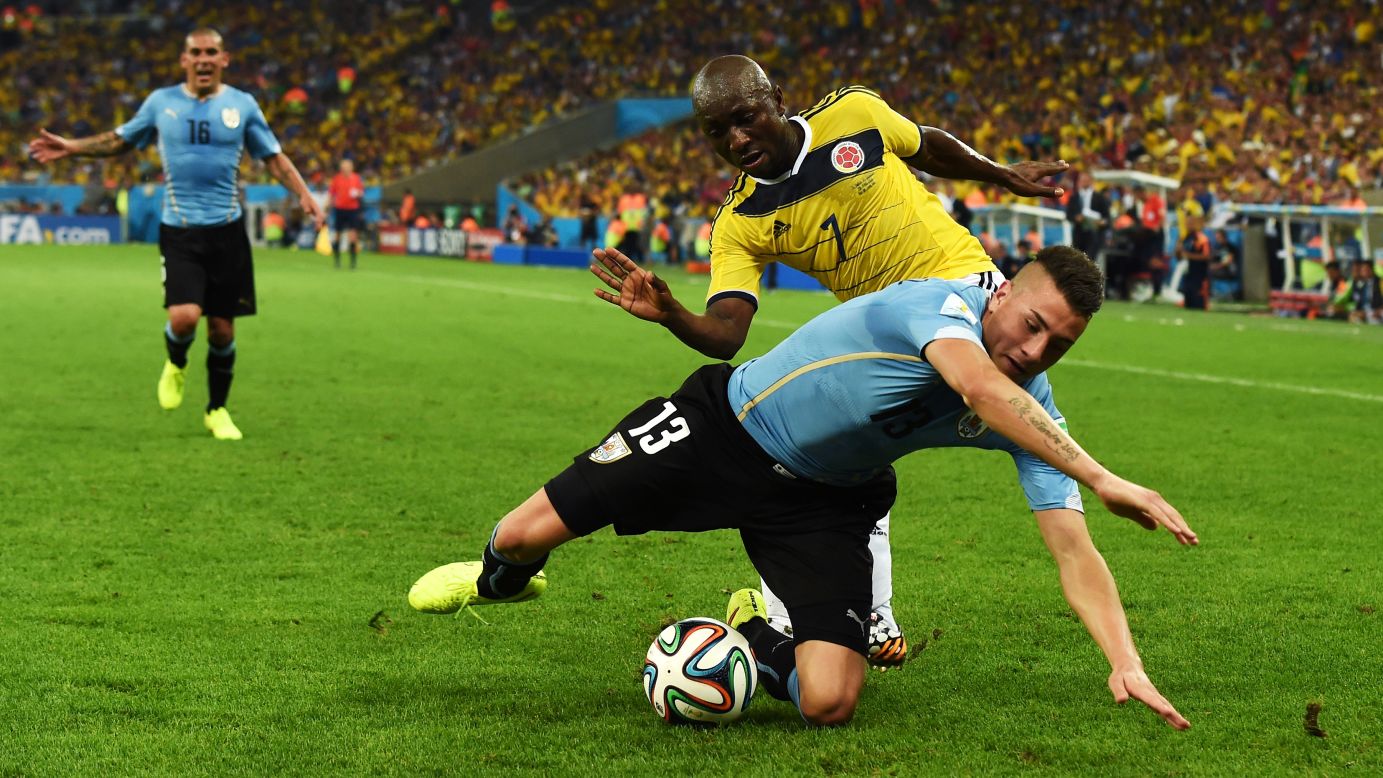 Jose Gimenez, in blue, of Uruguay is challenged by Pablo Armero of Colombia.
