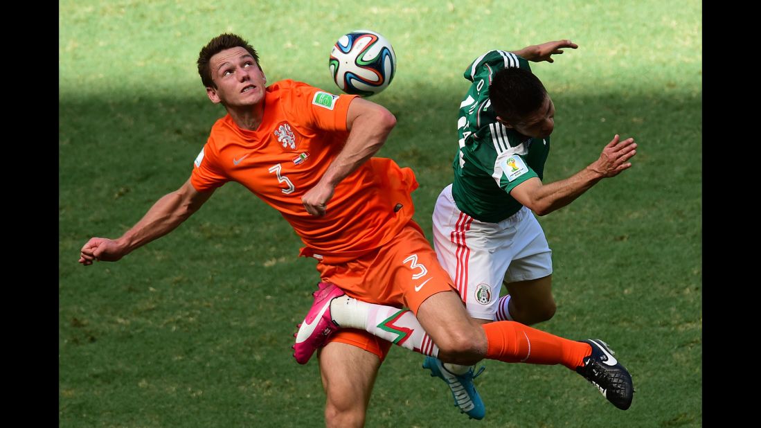 Stefan de Vrij of the Netherlands, in orange, challenges Oribe Peralta of Mexico for the ball during a World Cup game between the two nations in Fortaleza, Brazil, on Sunday, June 29.