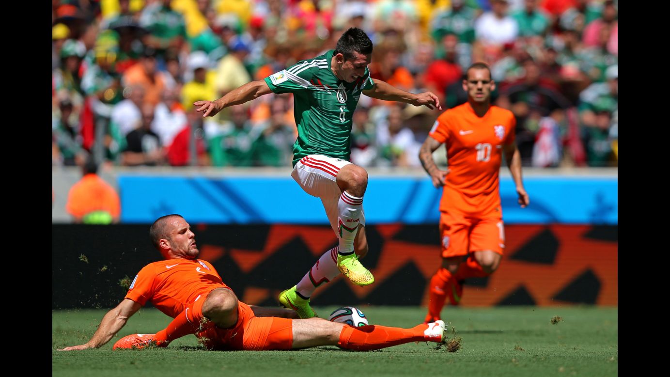 Ron Vlaar of the Netherlands tackles Hector Herrera of Mexico.