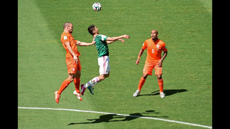 Mexico's Hector Moreno, center, is challenged by Ron Vlaar, left, and Nigel de Jong of the Netherlands.
