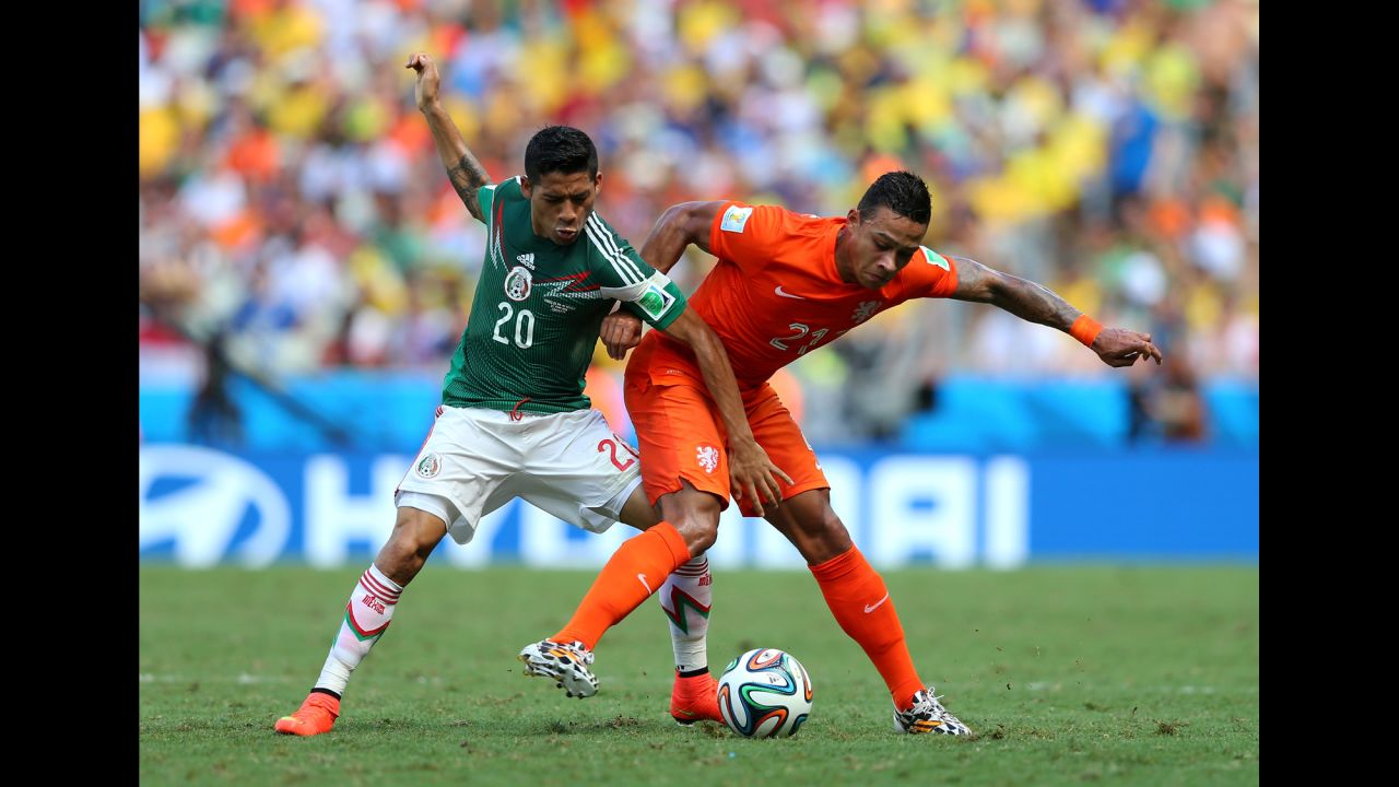 Memphis Depay of the Netherlands and Javier Aquino of Mexico compete for the ball. 
