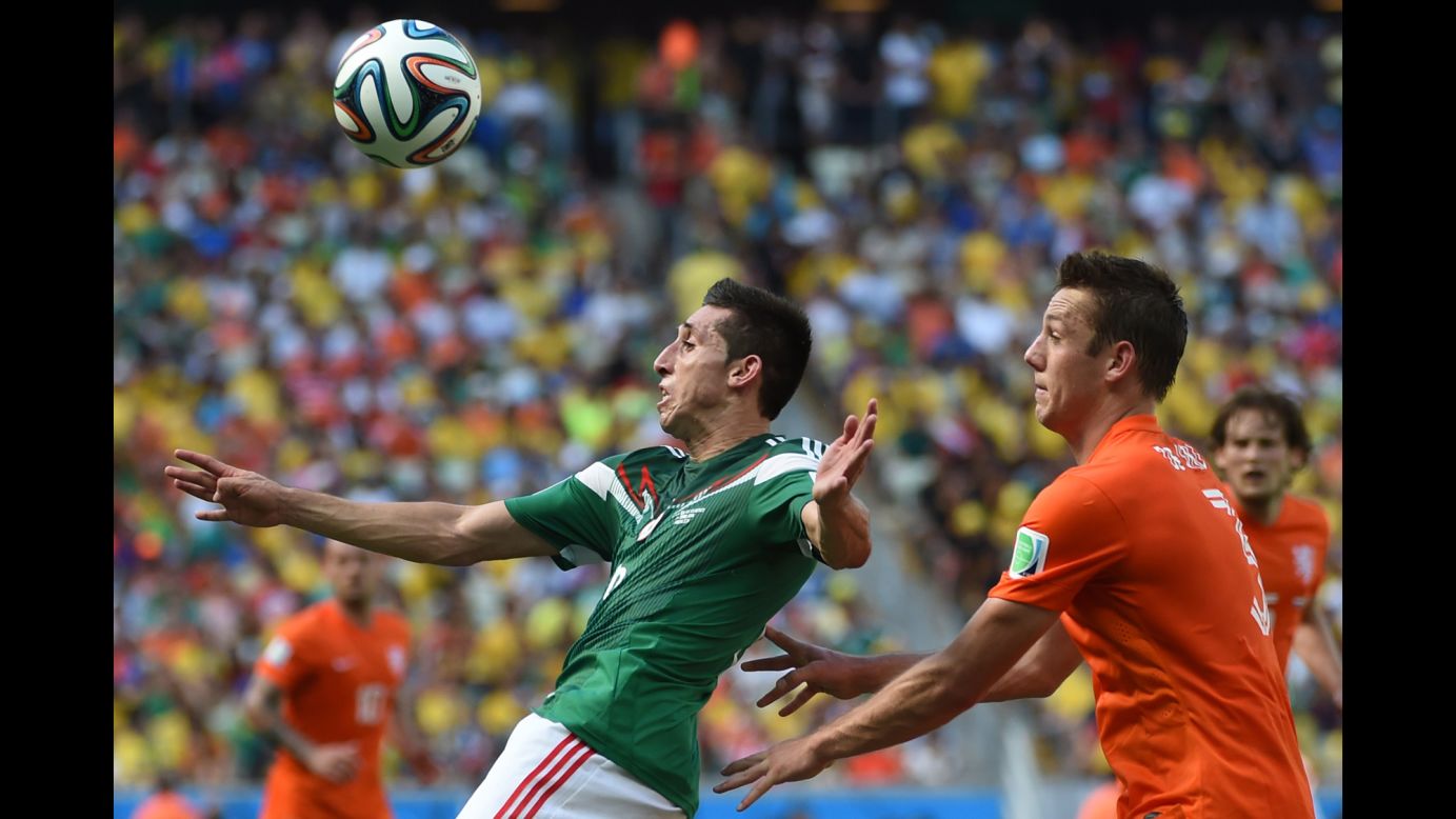 Mexico's Hector Herrera vies for the ball with Netherlands' Stefan de Vrij.