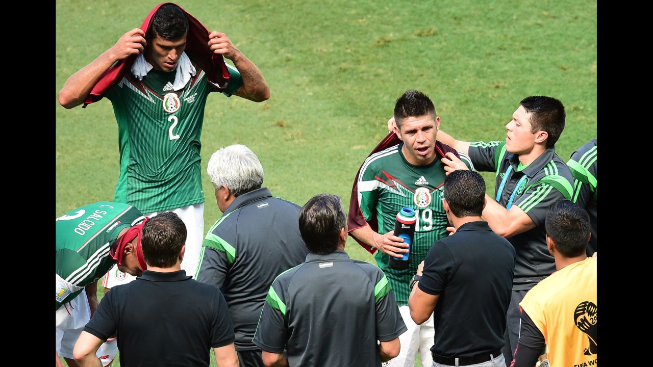 Francisco Rodriguez, left, and Oribe Peralta, second right, of Mexico take a three-minute cooling break allowed for both teams by the referee during the 30th and 75th minutes of the game.