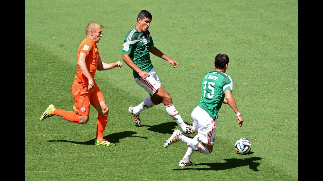 Arjen Robben of the Netherlands vies for the ball with Francisco Rodriguez, center, and Hector Moreno of Mexico.