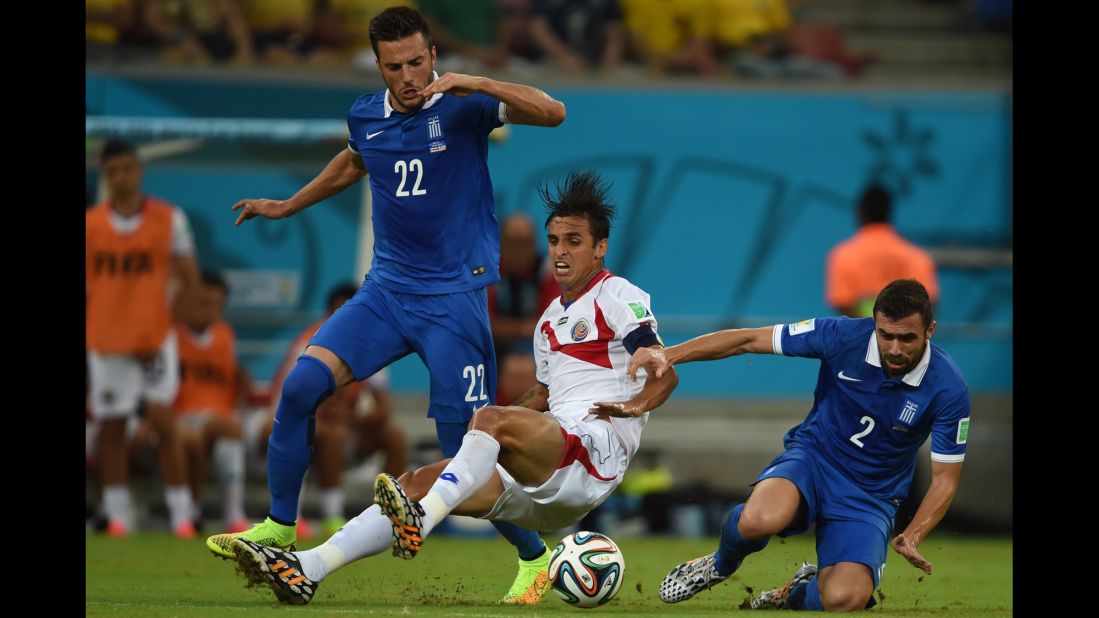 Costa Rica's captain Bryan Ruiz, center, competes for the ball with Greece's Andreas Samaris, left, and Greece's Giannis Maniatis.