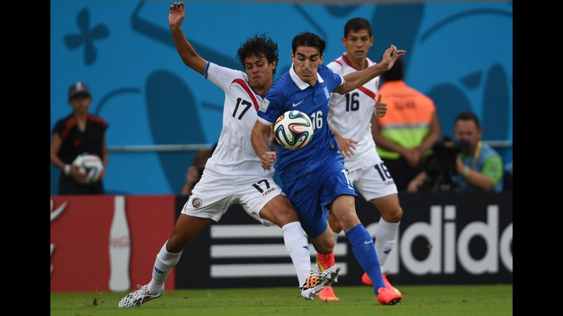 Yeltsin Tejeda, left, and Cristian Gamboa, right, of Costa Rica defend against Lazaros Christodoulopoulos of Greece.